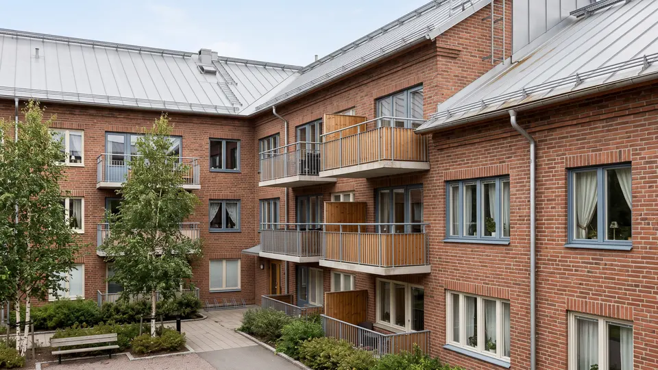 Illustration av ett flerbostadshus och dess gård